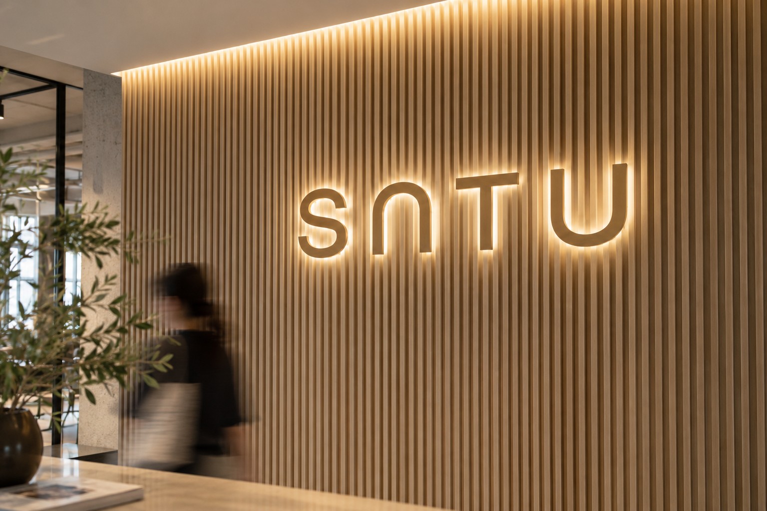 SATU brand visual with warm timber and illuminated lettering
